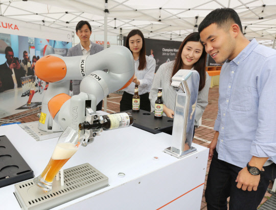 산업용 로봇 제조회사 쿠카로보틱스코리아㈜는 지난 29일 경기도 안산 경기테크노파크에서 초정밀 로봇 'KR3 아길러스(AGILUS)'의 출시 세미나를 열고, 실제 생산라인에서 적용 중인 로봇 자동화 솔루션을 소개했다. 뿐만 아니라 산업용 로봇과의 스피드 게임과 지능형 협업 로봇 LBR 이바와 함께하는 맥주 파티 등 이색적인 이벤트를 개최해 눈길을 끌었다. 이날 행사에서 산업용 로봇이 참석자들에게 맥주를 따라 주고 있다.  쿠카로보틱스코리아 제공